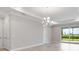 Bright, neutral living space with modern chandelier, sliding glass doors and light colored flooring at 26930 Lark Ct, Punta Gorda, FL 33955