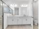 Modern bathroom boasts double sinks, sleek white cabinetry, and a luxurious glass-enclosed shower at 26936 Lark Ct, Punta Gorda, FL 33955