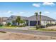 Contemporary home with a two car garage, manicured landscaping and mature palm trees at 26936 Lark Ct, Punta Gorda, FL 33955