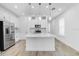 Bright kitchen featuring white cabinets, stainless steel appliances, and a large island with pendant lighting above at 26936 Lark Ct, Punta Gorda, FL 33955