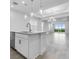 Bright kitchen featuring an island with sink, pendant lights, and adjacent to a dining area with sliders to backyard at 26936 Lark Ct, Punta Gorda, FL 33955