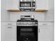 Close-up of a stainless steel range and microwave above white cabinets and drawers in a bright, modern kitchen at 26936 Lark Ct, Punta Gorda, FL 33955