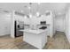 Bright kitchen featuring white cabinets, stainless steel appliances, and a large island with pendant lighting above at 26936 Lark Ct, Punta Gorda, FL 33955