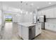 Bright kitchen featuring an island with sink, pendant lights, and adjacent to a dining area with sliders to backyard at 26936 Lark Ct, Punta Gorda, FL 33955