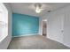 Bedroom with gray carpet, a ceiling fan and one accent wall painted bright blue at 2838 Newbern Banks Dr, Bradenton, FL 34208