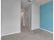 View of a bedroom with adjoining hallway and doorways, featuring gray carpet and blue accent wall at 2838 Newbern Banks Dr, Bradenton, FL 34208