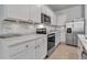 Bright kitchen featuring stainless steel appliances, white cabinets, and marble countertops at 2838 Newbern Banks Dr, Bradenton, FL 34208