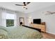 Bedroom featuring a queen bed, a dresser with a television, and a large window at 3417 Tallywood Ln, Sarasota, FL 34237