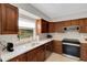 Well-lit kitchen with wooden cabinets, stone countertops, and stainless steel appliances at 3417 Tallywood Ln, Sarasota, FL 34237