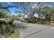 Street view of homes showing the mature shade trees, landscaping and quiet neighborhood at 3417 Tallywood Ln, Sarasota, FL 34237