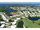 Aerial view of a neighborhood with a pool and recreational area, surrounded by natural waterways at 3708 Chinaberry Rd, Bradenton, FL 34208