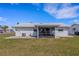 The back of the house has a small concrete patio with a screened lanai, overlooking the lawn at 3708 Chinaberry Rd, Bradenton, FL 34208