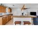 An open kitchen features wood cabinets, a breakfast bar, and a view into the living area at 3708 Chinaberry Rd, Bradenton, FL 34208
