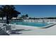 Large community pool surrounded by lounge chairs and a white picket fence under a clear blue sky at 3708 Chinaberry Rd, Bradenton, FL 34208