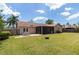 Expansive backyard with lush lawn, screened patio, outdoor seating, and privacy fence at 3739 Kingston Blvd, Sarasota, FL 34238