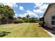 Green backyard with lush lawn, perimeter landscaping, and wood fence for privacy at 3739 Kingston Blvd, Sarasota, FL 34238