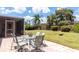 Backyard patio with dining set and a view of the large grassy yard at 3739 Kingston Blvd, Sarasota, FL 34238
