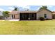 Green backyard with lush lawn, outdoor seating, and screened patio for relaxing at 3739 Kingston Blvd, Sarasota, FL 34238