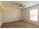 Carpeted bedroom featuring a ceiling fan, closet, and a window with plenty of natural light at 3739 Kingston Blvd, Sarasota, FL 34238