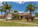 Beautiful single-story home featuring a well-manicured lawn, mature palm trees, and inviting curb appeal at 3739 Kingston Blvd, Sarasota, FL 34238