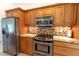 Kitchen with stainless steel appliances, mosaic backsplash, and wood cabinets at 3739 Kingston Blvd, Sarasota, FL 34238