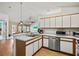 Bright kitchen with stainless steel appliances and white cabinets, plus a view into the living room at 406 116Th E St, Bradenton, FL 34212