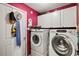 Well-equipped laundry room with washer, dryer, overhead cabinets, and ample storage space at 406 116Th E St, Bradenton, FL 34212