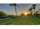 Expansive backyard featuring vibrant green grass, towering palm trees, and a tranquil beachside ambiance at 4473 Gulf Of Mexico Dr, Longboat Key, FL 34228