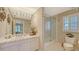 Tidy bathroom featuring a shower over the tub, white tile and plentiful light at 4473 Gulf Of Mexico Dr, Longboat Key, FL 34228