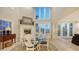 Elegant dining area with fireplace, tall windows, and seating for four at 4473 Gulf Of Mexico Dr, Longboat Key, FL 34228