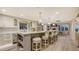 Gourmet kitchen featuring white cabinets, stainless steel appliances, and a large island with bar seating at 4473 Gulf Of Mexico Dr, Longboat Key, FL 34228