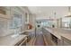 Modern kitchen with a stainless steel farm sink and stainless appliances, open to a dining area and living space with a fireplace at 4473 Gulf Of Mexico Dr, Longboat Key, FL 34228