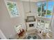 A bright living room features high ceilings, many windows, a fireplace, and a table with chairs at 4473 Gulf Of Mexico Dr, Longboat Key, FL 34228
