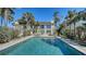 Inviting pool and backyard with lush greenery, palms, and beautiful exterior, ideal for relaxation at 4473 Gulf Of Mexico Dr, Longboat Key, FL 34228