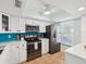 Bright kitchen with stainless steel appliances, white cabinets, and a window providing natural light at 460 S Paula Dr # 304, Dunedin, FL 34698