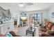 Cozy living room with a ceiling fan, comfortable seating, and a sliding glass door to a balcony with a view at 460 S Paula Dr # 304, Dunedin, FL 34698
