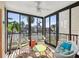 Relaxing sunroom with wicker furniture, large windows, and a bright rug at 460 S Paula Dr # 304, Dunedin, FL 34698