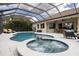Screened-in backyard with in-ground pool, spa, and comfortable seating area at 4721 Mainsail Drive, Bradenton, FL 34208