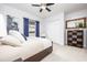 Comfortable bedroom with a ceiling fan, a dresser and a window with blue curtains at 4721 Mainsail Drive, Bradenton, FL 34208