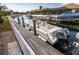 Pristine white boat docked on a canal with lush landscaping and upscale homes in the backdrop, perfect for waterfront living at 4721 Mainsail Drive, Bradenton, FL 34208