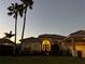Inviting front exterior of home with well-manicured lawn and lush landscaping at dusk at 4721 Mainsail Drive, Bradenton, FL 34208
