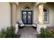 Charming front porch featuring double doors with decor, seating and manicured landscaping at 4721 Mainsail Drive, Bradenton, FL 34208