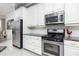 Modern kitchen with stainless steel appliances, granite countertops, and subway tile backsplash at 4721 Mainsail Drive, Bradenton, FL 34208