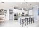 Bright kitchen features white cabinetry, stainless steel appliances, and bar seating at the island at 4721 Mainsail Drive, Bradenton, FL 34208
