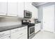 Updated kitchen with stainless steel appliances, white cabinetry, and granite countertops at 4721 Mainsail Drive, Bradenton, FL 34208