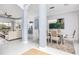 Open-concept living and dining area with modern chandelier, columns, and tile flooring at 4721 Mainsail Drive, Bradenton, FL 34208
