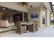 Covered patio with ceiling fan, wall-mounted TV, and dining table at 4721 Mainsail Drive, Bradenton, FL 34208