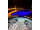Relaxing evening view of the pool and spa with ambient lighting and lounge chairs at 4721 Mainsail Drive, Bradenton, FL 34208