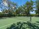 Well-maintained tennis court surrounded by lush greenery, perfect for recreational enjoyment at 4721 Mainsail Drive, Bradenton, FL 34208