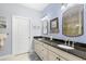 Bathroom featuring double sinks, dark granite countertops, and framed mirrors at 4805 Heinman Cv, Palmetto, FL 34221